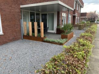 Plantnebak metaal cortenbakken bij de ingang onderhoudsarme tuin